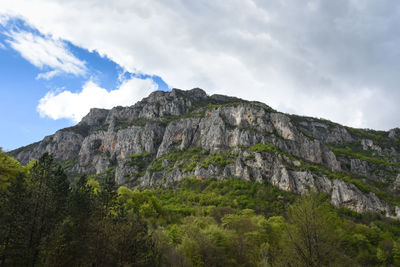 Low angle view of rocky mountain against sky