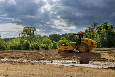 View of machinery on land against cloudy sky