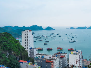 High angle view of city by sea against sky