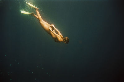 Woman free diving near nusa penida, bali, indonesia. nikonos v on 35mm cinestill 400d film.