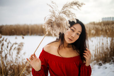 Asian lady in red dress in winter reeds