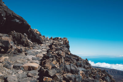 Steps towards volcano peak against clear blue sky