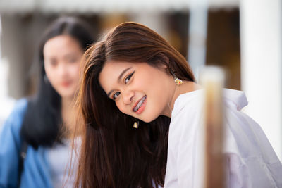 Portrait of smiling teenage girl with long hair outdoors