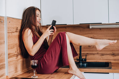 Young woman using mobile phone at home