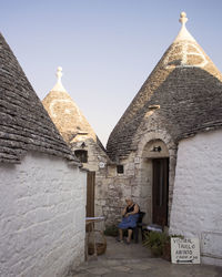 Rear view of man by old building against sky