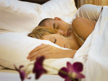 High angle view of couple sleeping on bed at home