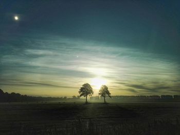 Scenic view of field against sky at sunset