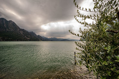 Scenic view of sea by mountains against sky