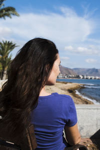 Rear view of woman looking at sea against sky