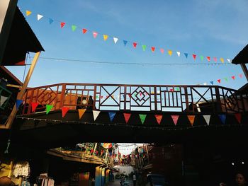 Low angle view of people on bridge against sky