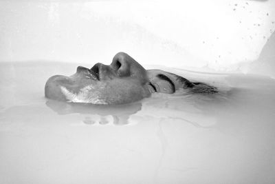 Close-up of man lying in the bathroom