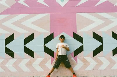 Full length of woman standing against wall
