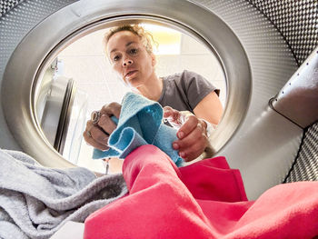 Low angle view of woman washing in car