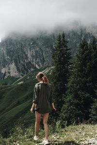 Full length of woman standing on mountain against sky