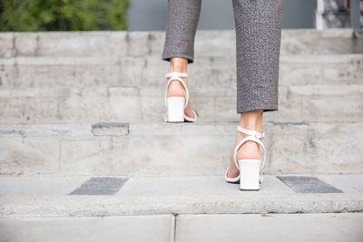 Low section of woman standing on footpath