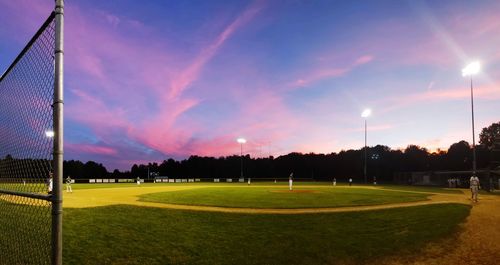 Scenic view of soccer field against sky during sunset