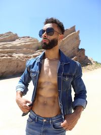 Portrait of young man standing against mountain