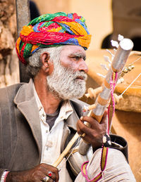 Portrait of man holding multi colored umbrella