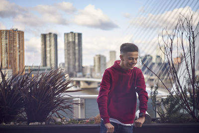 Portrait of smiling man standing against buildings in city