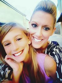 Close-up portrait of smiling young woman against sky