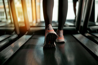 Low section of woman exercising on treadmill