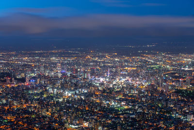 High angle view of illuminated cityscape against sky at night