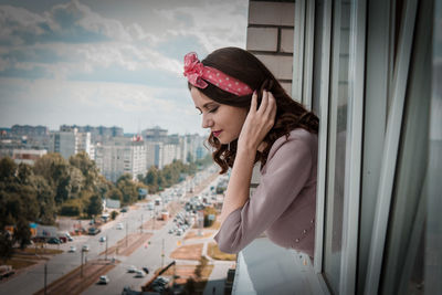 Woman peeking from window in city