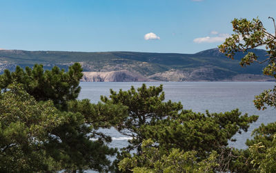 Scenic view of sea and mountains against sky