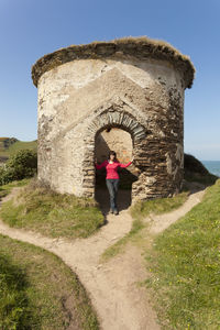 Portrait of woman standing at old ruin entrance 