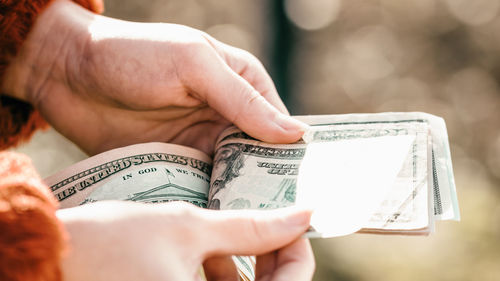 Cropped hand of woman holding paper currency