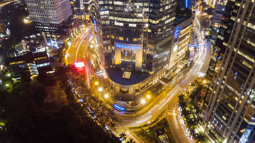 High angle view of illuminated street amidst buildings at night