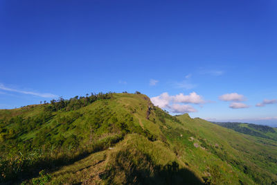 Scenic view of mountains against blue sky