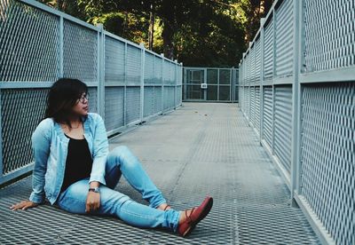 Woman sitting on overpass