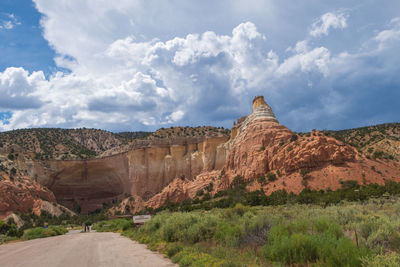 Rock formations on landscape against cloudy sky