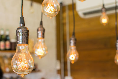 Close-up of illuminated light bulb on table