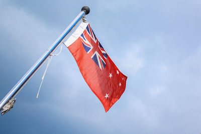 Low angle view of red flag against sky