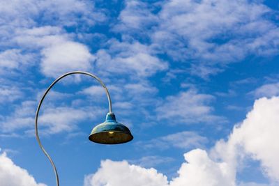 Low angle view of street light against cloudy blue sky