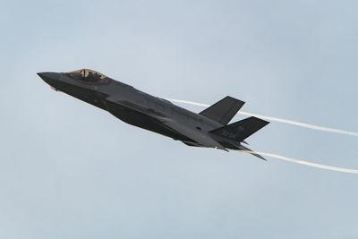 Low angle view of airplane flying against sky