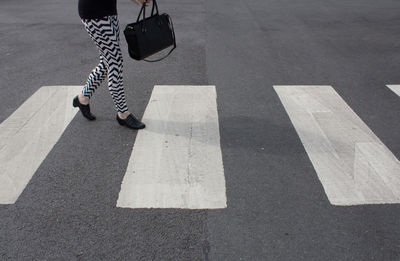 Low section of woman walking on road