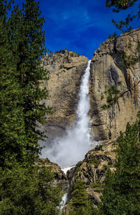 Scenic view of waterfall against sky