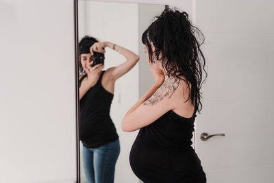 Pregnant woman photographing in front of mirror