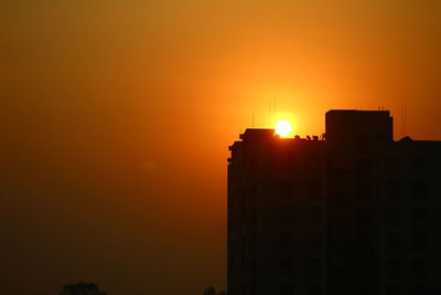 Silhouette of buildings against sky during sunset