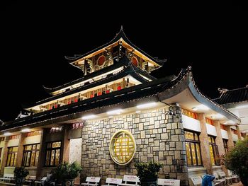 Low angle view of illuminated building against sky at night