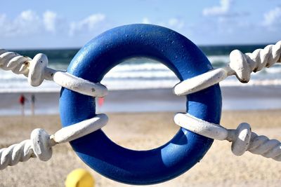 Close-up of metallic chain against sea