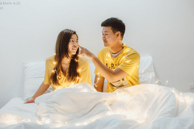 Young couple sitting on bed