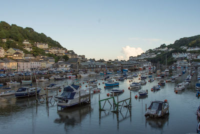 Boats moored at harbor against clear sky