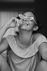 Close-up of smiling young woman wearing eyeglasses at home