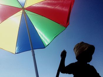 Low angle view of boy against blue sky