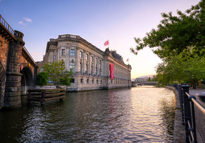 Bridge over river by buildings in city