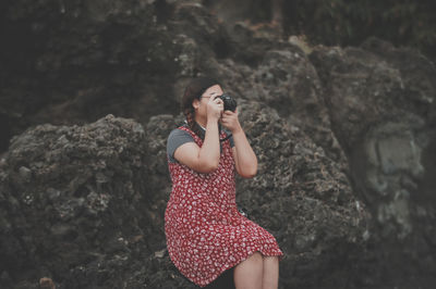 Young woman standing on rock at shore